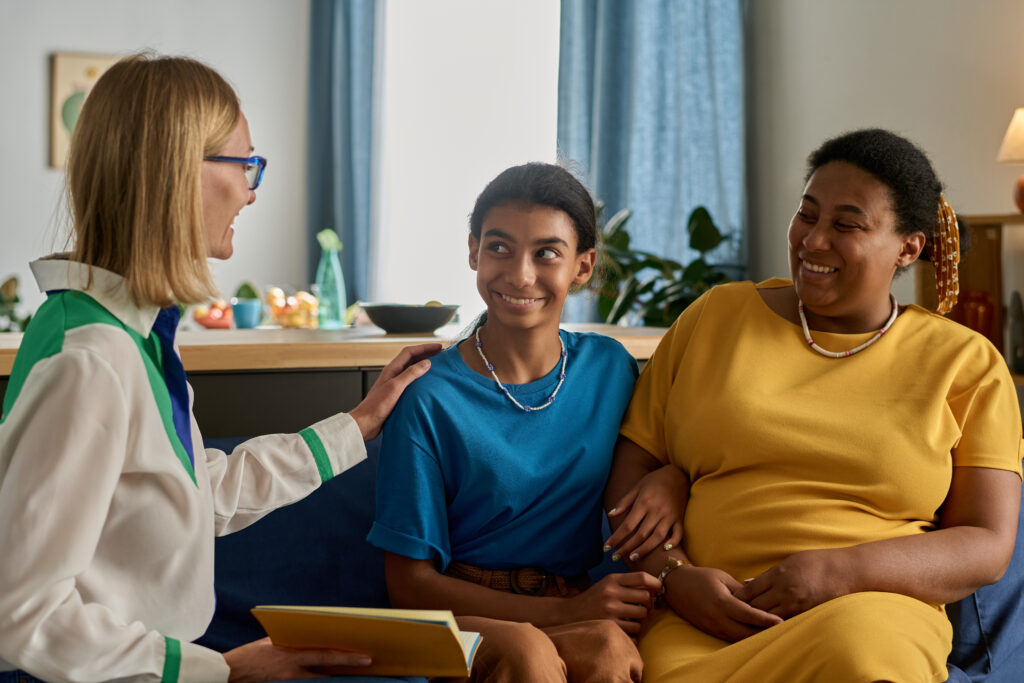 Social worker talking to mom and her adult daughter during their meeting at home